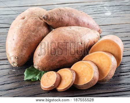 Sweet potatoes on the old wooden table.