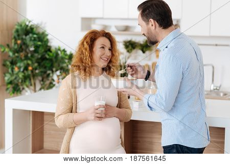 True love. Mature man taking care of his full term pregnant wife during a healthy family breakfast.