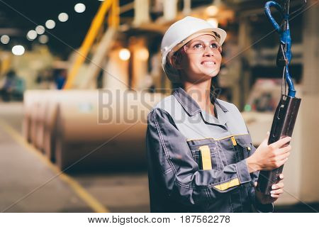 woman operating crane at paper mill factory