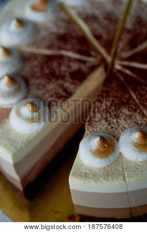 four layer cake with shades of brown. Here cream to chocolate.