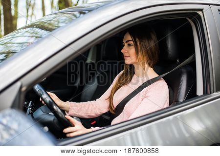 Young Woman Driving Her Car With Safity Belt On Street Road. Safe Drive