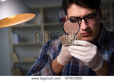 Archeologist working late night in office