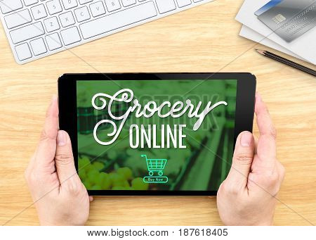 Hand Holding Tablet With Grocery Online Word On Wood Table ,shopping Online Concept.