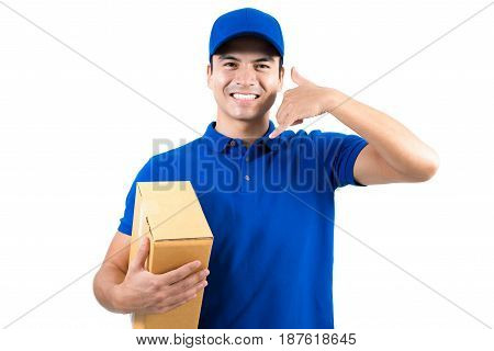 Smiling handsome delivery man holding box and making call me gesture - isolated on white background