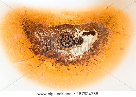 Old dirty white sink with brown stain