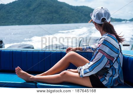 Side View. Asia Woman Sitting On Back Of Boat And Looking Scenery Sea View Have Island Are Backgroun