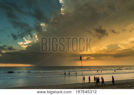 Beautiful sunset of Kuta Beach Bali Indonesia. Silhouettes of people at sunset on Kuta beach in Bali Indonesia