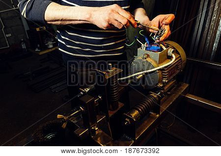 Senior technician repairing agriculture machinery in a greenhouse