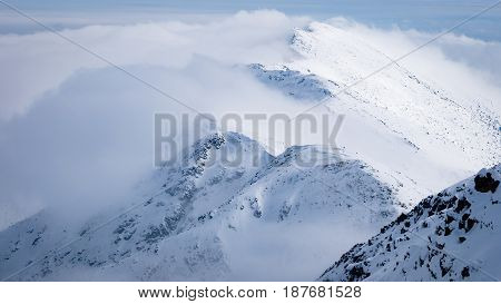 Highest points of Low Tatras - Chopok peak and Dumbier peak (Slovakia). Beautiful winter mountains landscape above the clouds.