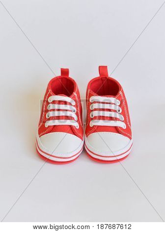 Red sneakers Baby shoes for newborns on isolated background