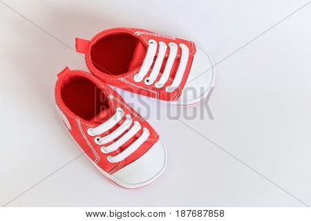 Red sneakers Baby shoes for newborns on isolated background