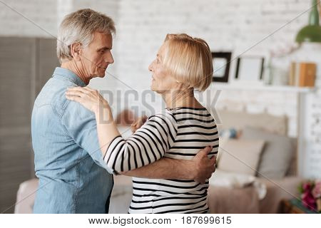 Motion of love. Active emotional senior couple sharing a romantic moment while enjoying their time and spending it at home
