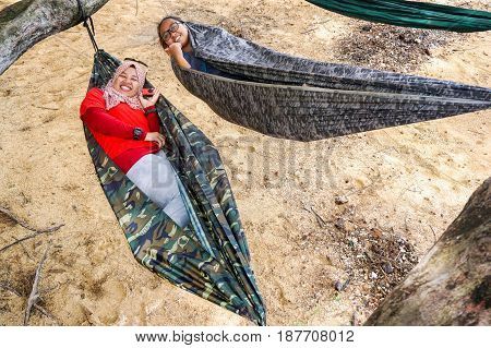 Labuan,Malaysia-Feb 19,2017:Young people relaxing & enjoying the hammock on tropical beach in Papan island,Labuan,Malaysia.
