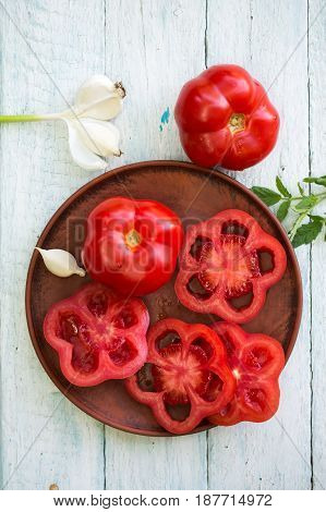 Fresh red tomato on a plate with garlic