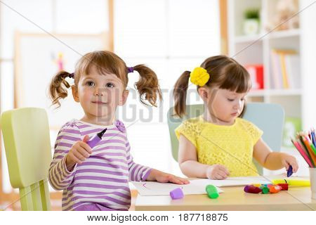 Kids drawing in kindergaten. Children paint in nursery. Preschooler with pen at home. Creative toddlers.
