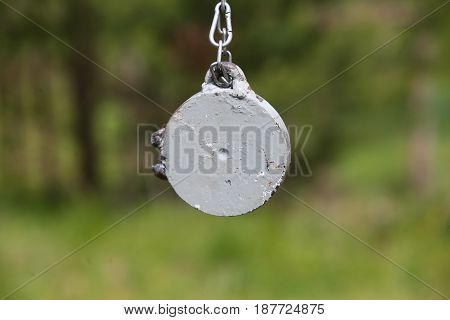 Target for training shooting. Metal on the chain.