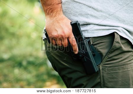 Pistol in the holster. The shooter trains. Is preparing to shoot at the target.