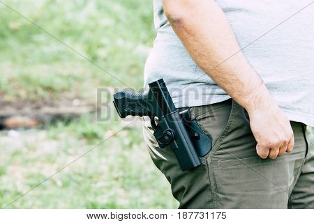 Pistol in the holster. The shooter trains. Is preparing to shoot at the target.
