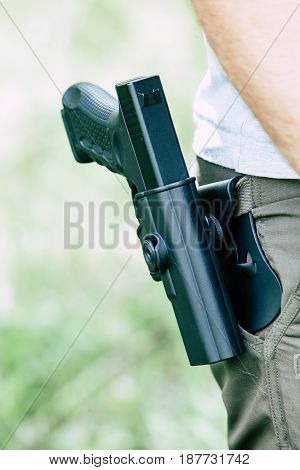 Pistol in the holster. The shooter trains. Is preparing to shoot at the target.