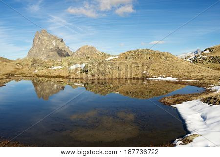 Midi Dossau Peak reflected in a lake. Ossau Valley, Pyrenees National Park, Pyrenees, France.