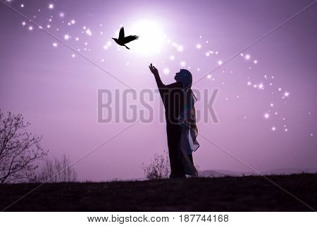  Copy space of silhouette woman rising hands on sunset sky double exposure colorful bokeh and bird fly background. Vintage tone filter effect color style.