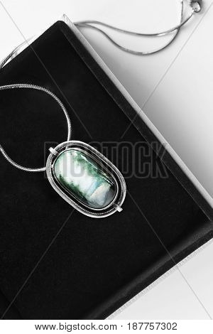 Vintage silver enameled medallion in black jewel box closeup