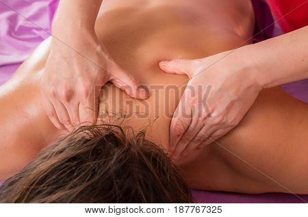 Woman receiving back massage. Healing touch of a massage hands.