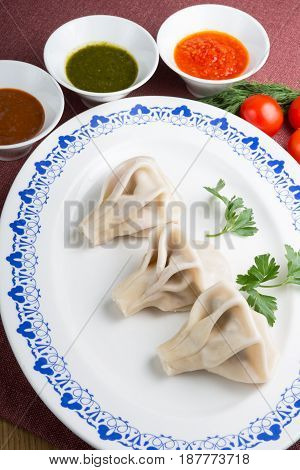 Traditional georgian hinkali dish with herbs and sauces