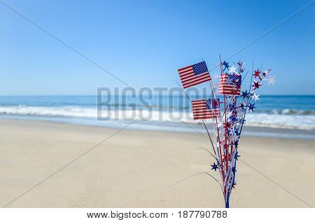 Patriotic USA background with flags and decorations on the sandy beach