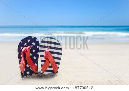 Patriotic USA background with flip flops and decorations on the sandy beach