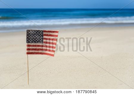 Patriotic USA background with flags and decorations on the sandy beach
