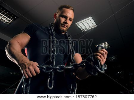 Professional Powerlifter Stands In The Gym With Iron Chains