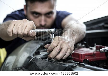Car Mechanic Man At The Garage Fixing The Engine