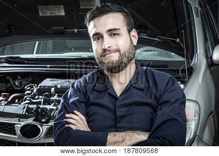 Car Mechanic Man At The Garage Fixing The Engine