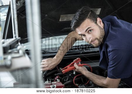 Car Mechanic Man At The Garage Fixing The Engine