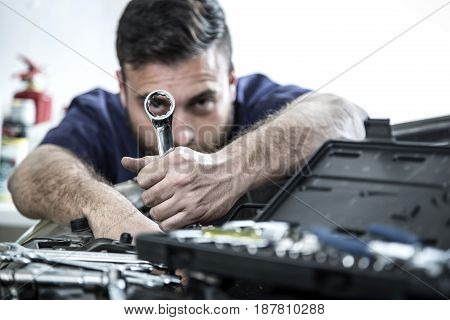 Car Mechanic Man At The Garage Fixing The Engine