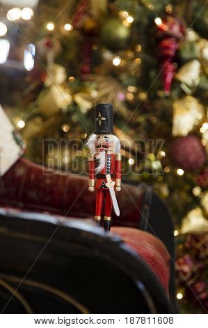 Nutcracker standing in front of a Christmas tree