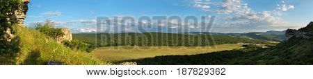 Evening panorama of the green valley. View from the top of the cave city Bakla in Crimea.