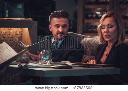 Friends rading menu in a restaurant.