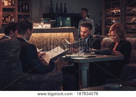 Friends rading menu in a restaurant.