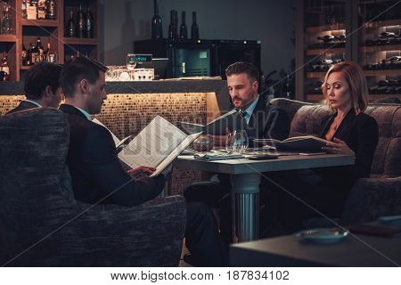 Friends rading menu in a restaurant.