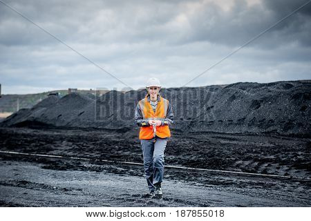 coal mining worker walking through open pit