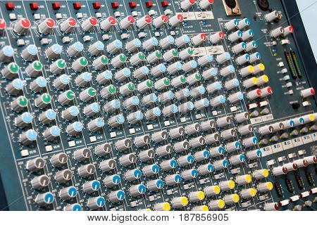 Sound mixing console with lots of buttons and knobs.