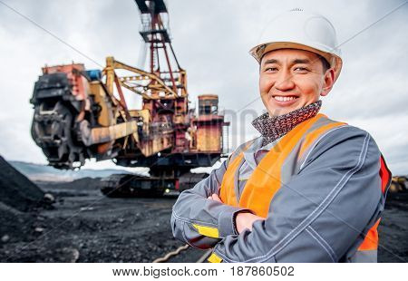 coal mining worker with rotary excavator on the background