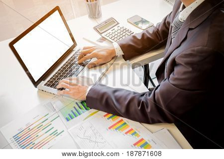 Close up of hand of business man working document and laptop in office morning light. business concept.