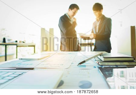 young coworkers crew working with new startup project in modern loft. Pen laptop analyze plans on desk.