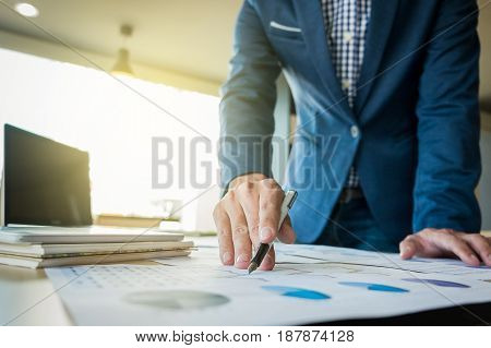 Close up of hand of business man working document and laptop in office morning light. business concept.