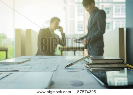 young coworkers crew working with new startup project in modern loft. Pen laptop analyze plans on desk.