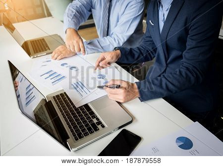 Two businessmen looking at report and having a discussion in office. business concept.