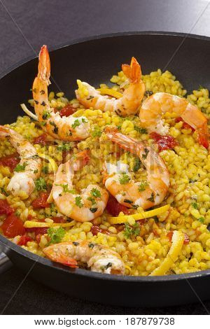 Delicious paella food in black pan with shrimps.Typical spanish dish.